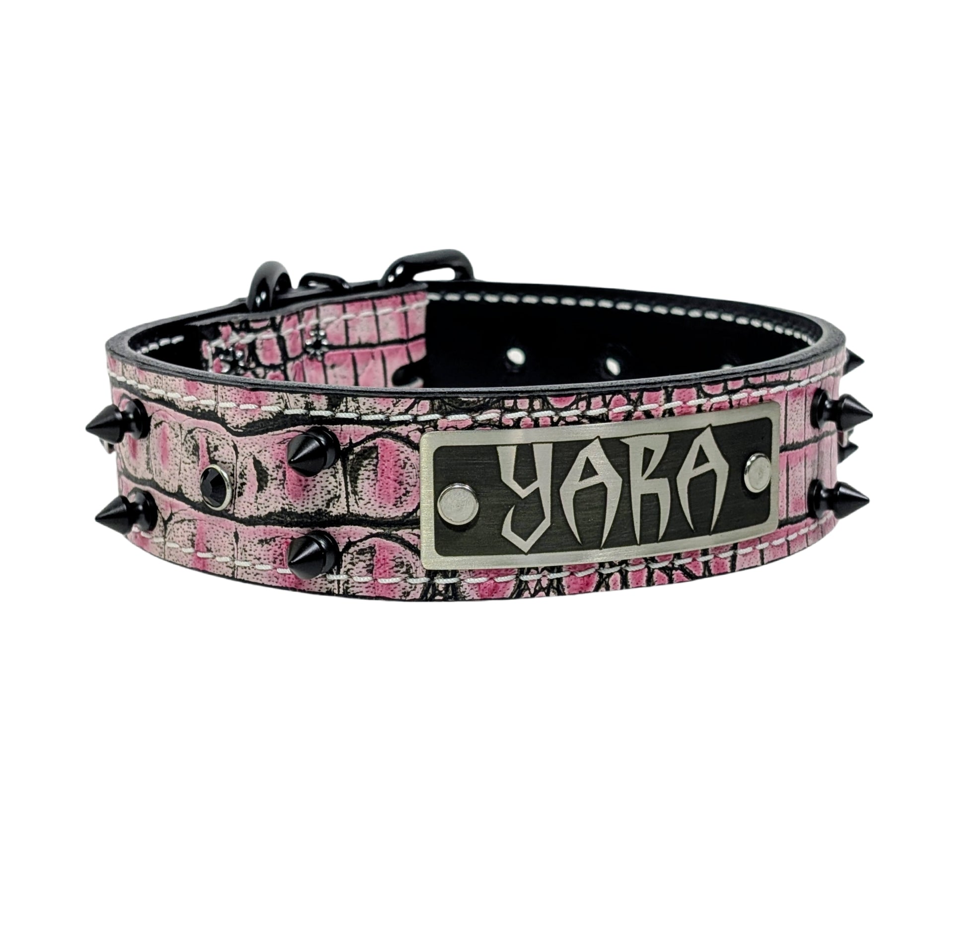 Pink camouflage dog collar with black spikes and a nameplate on a white background